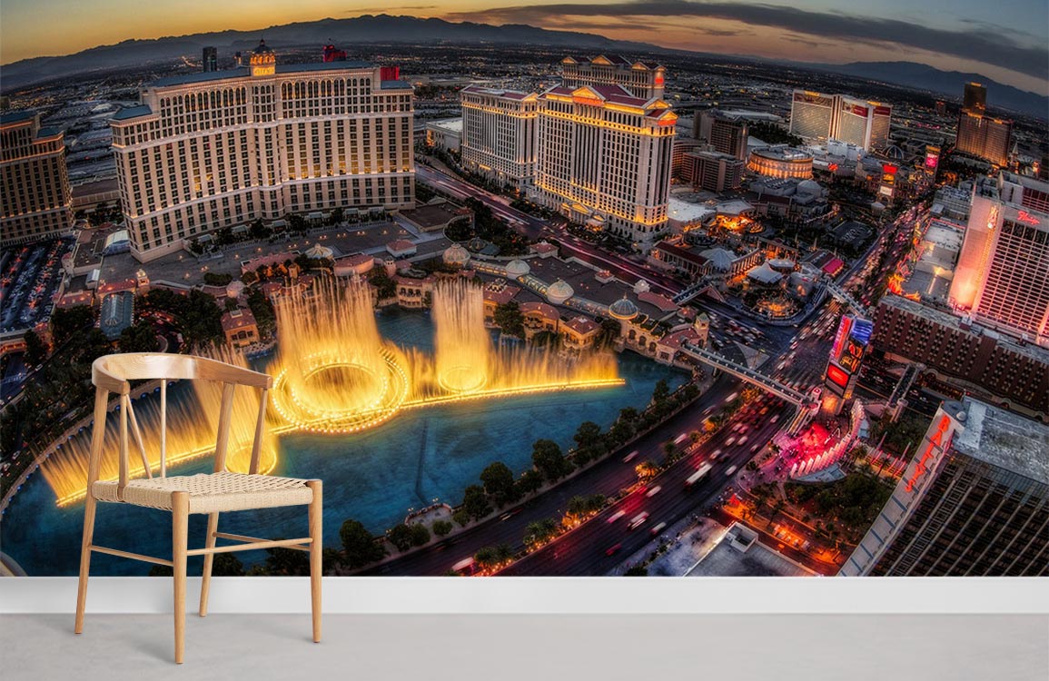 Luxurious Las Vegas skyline mural wallpaper features illuminated fountains, modern wooden chair, in living room.