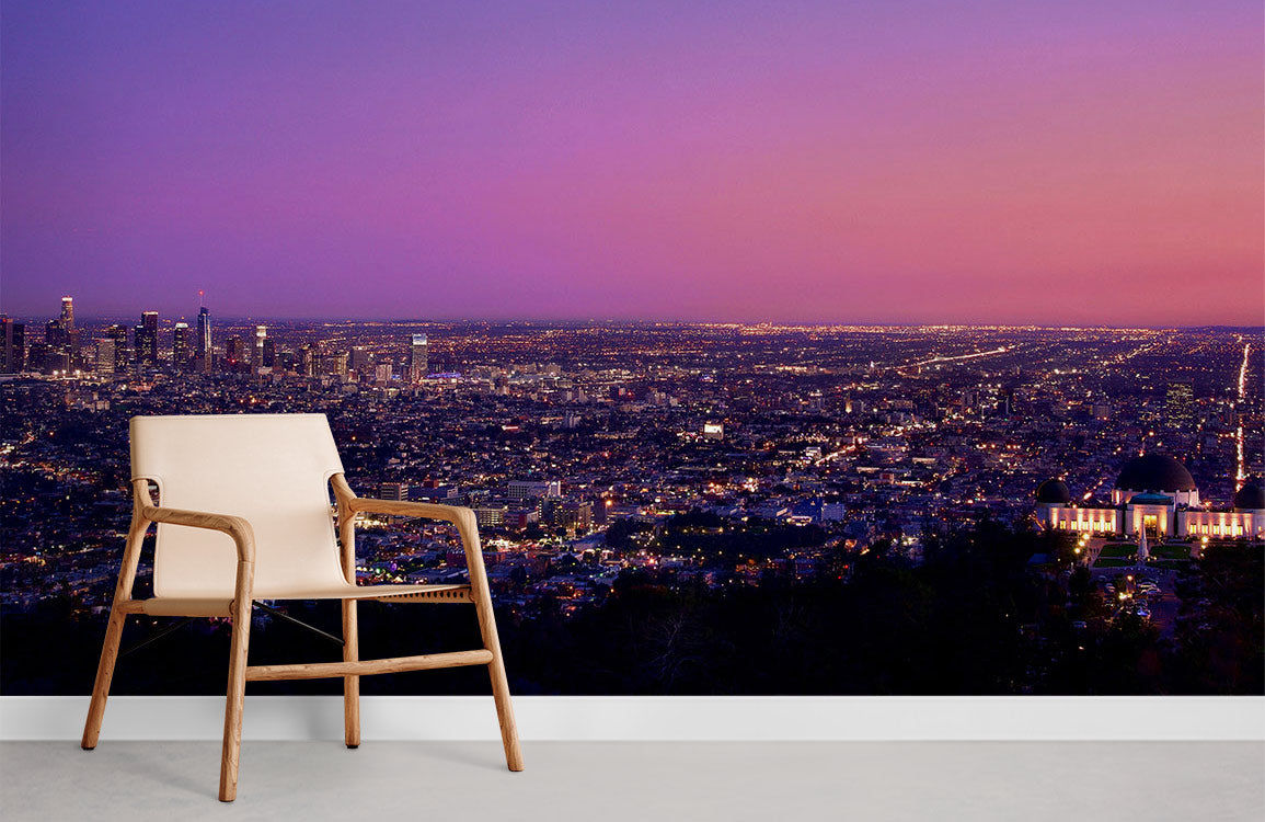 Elegant twilight cityscape mural with beige modern chair, grey floor, and purple-pink urban wallpaper.