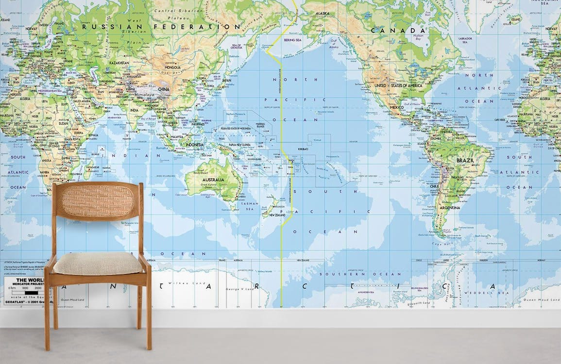 Vintage world map mural, blue-green wallpaper in a modern living room with minimalist wooden chair.