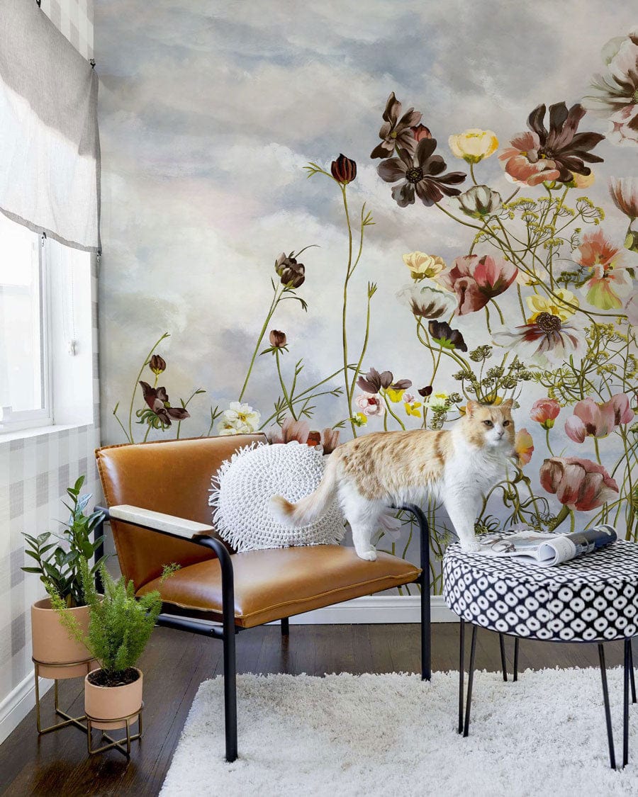Vintage floral mural wallpaper, soft pastel sky tones, brown leather chair, white rug, living room.