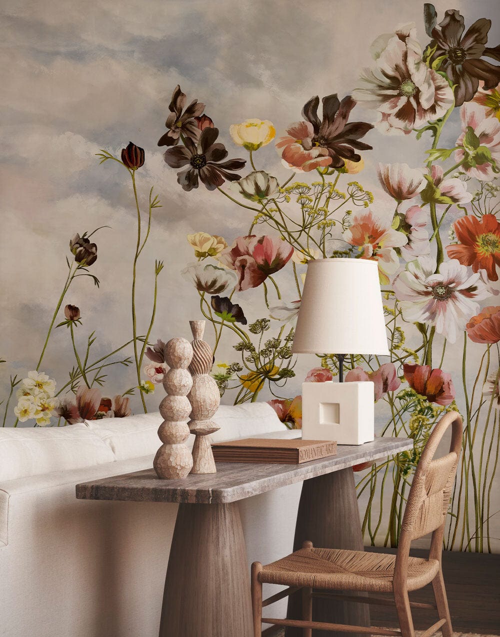 Vintage floral watercolour mural wallpaper in soft pastel tones, wooden desk, lamp, white sofa.