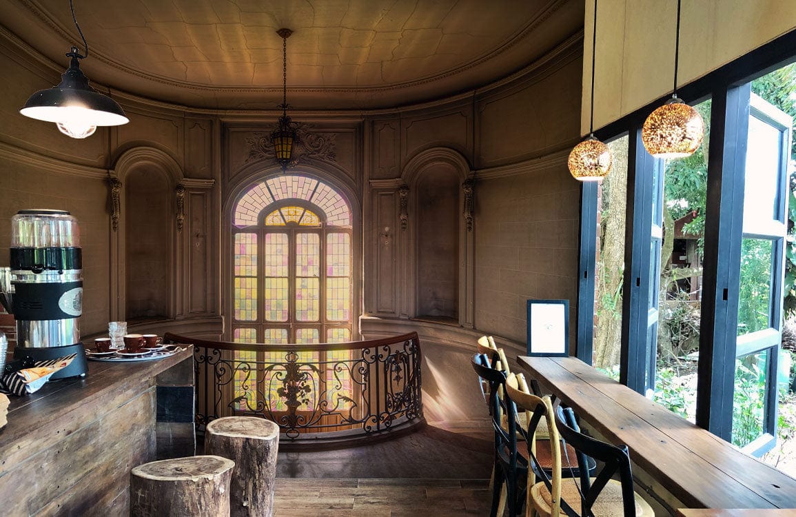 Elegant vintage architecture mural wallpaper in cosy café with wooden floors and stylish seating.