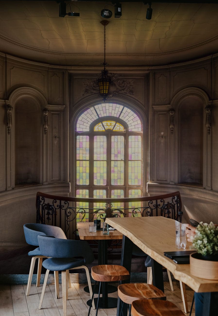 Elegant Vintage Mural Wallpaper in dining area, arched window design, wooden flooring, modern chairs.