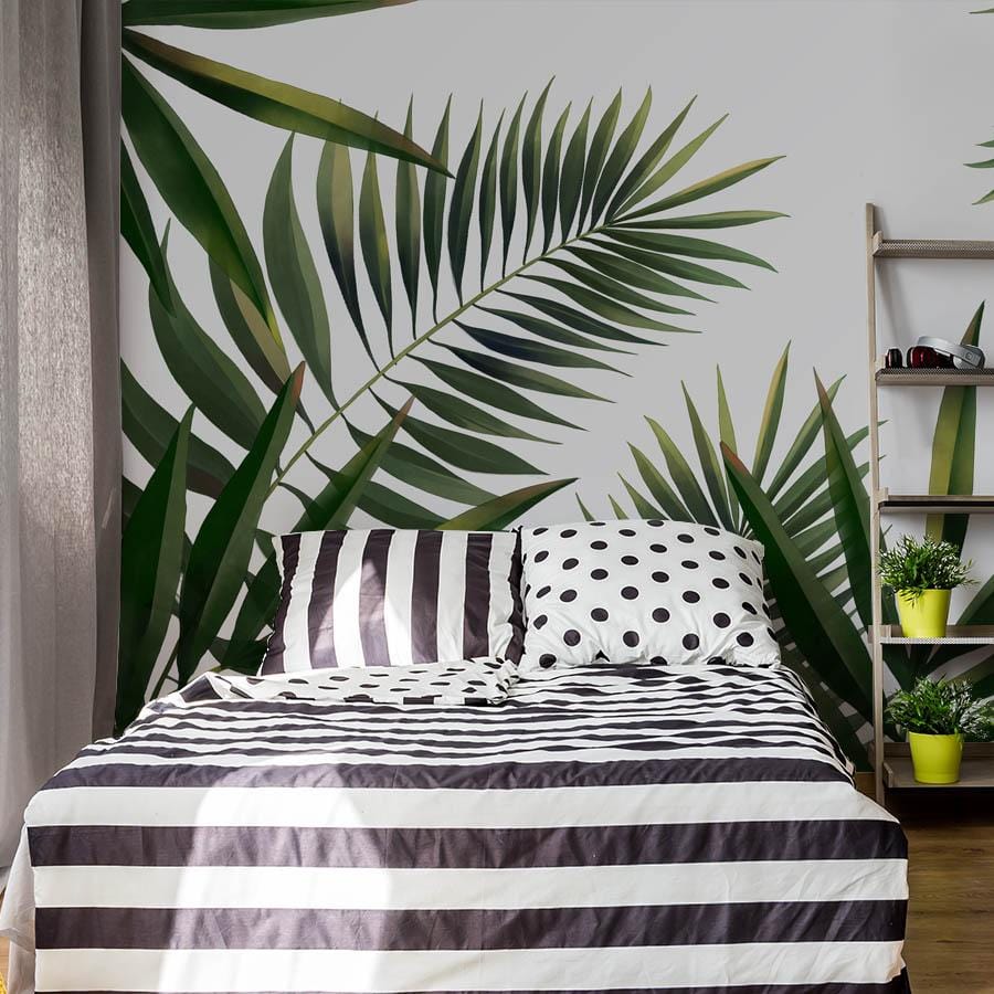 Elegant green palm leaves mural wallpaper, modern bedroom with striped bedding, wooden floor, polka dot cushions.