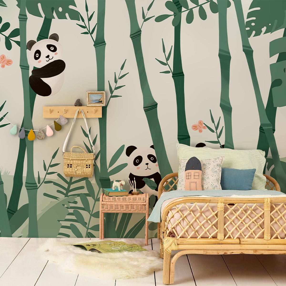 Children's room with bamboo jungle mural wallpaper, featuring pandas, wicker bed, and soft green accents.