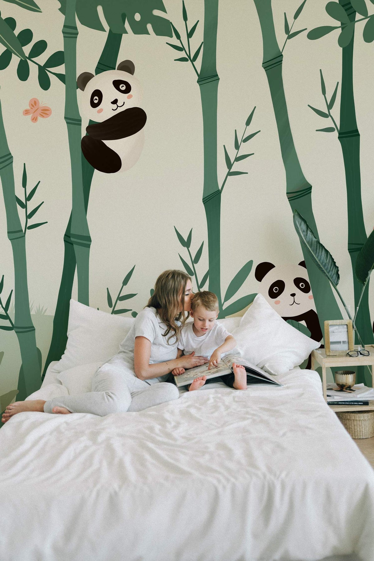Child's bedroom with Playful Panda Bamboo Jungle Mural Wallpaper, green and black tones, white bedding.