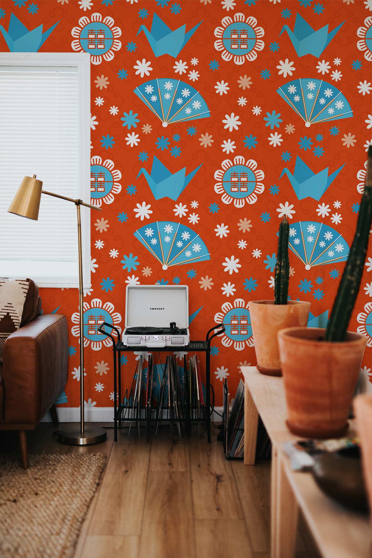 Vintage Japanese floral fan wallpaper, orange and blue, living room, leather sofa, wooden flooring.