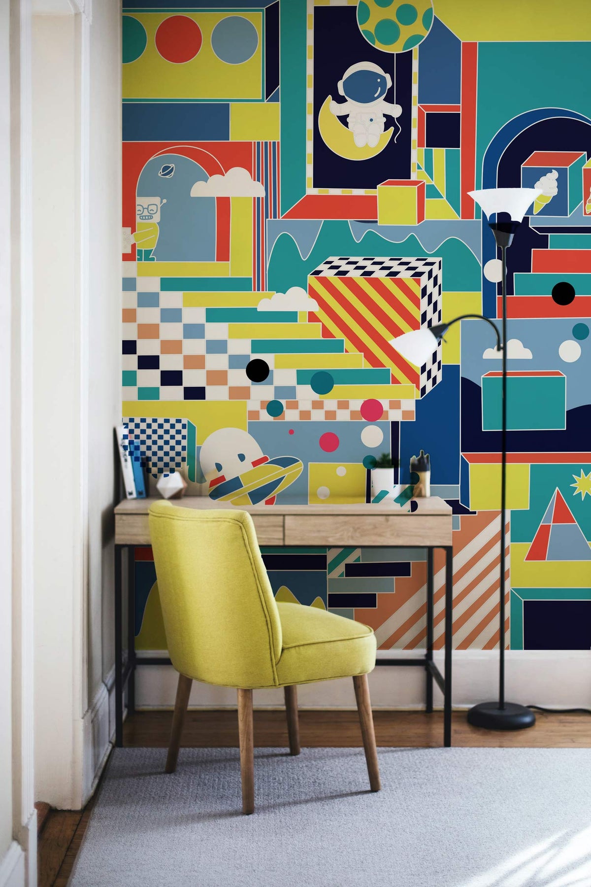Retro futuristic mural wallpaper in playroom; features yellow chair, wooden desk, light hardwood flooring.