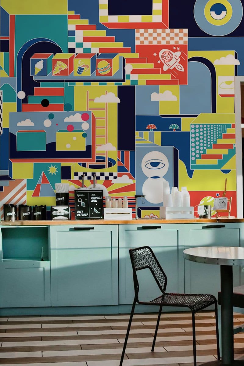 Retro futuristic multicolour mural in kitchen, pastel cabinets, modern black chair, striped flooring.