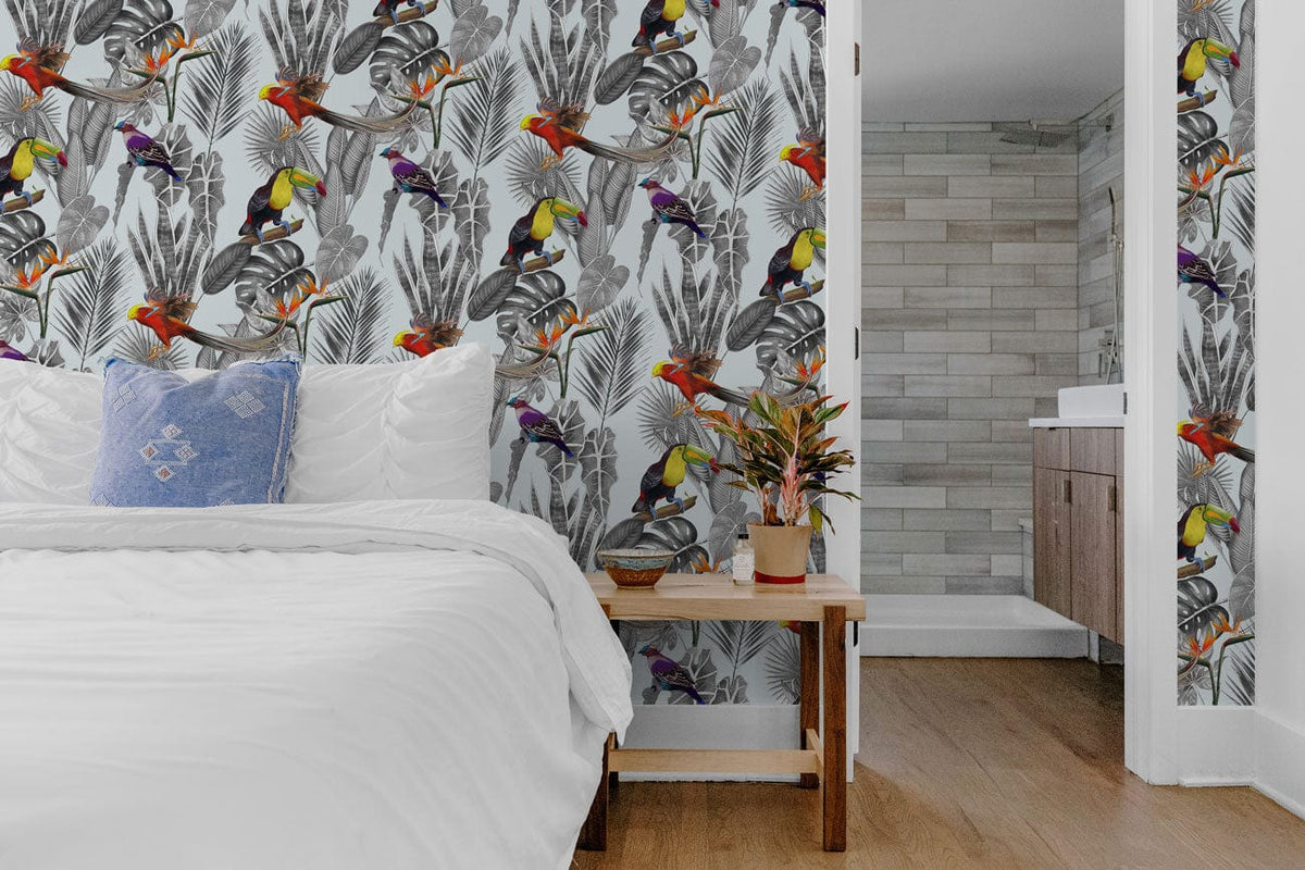 Tropical Paradise Jungle Birds Wallpaper in bedroom with wooden flooring, white bedding, and blue cushion.