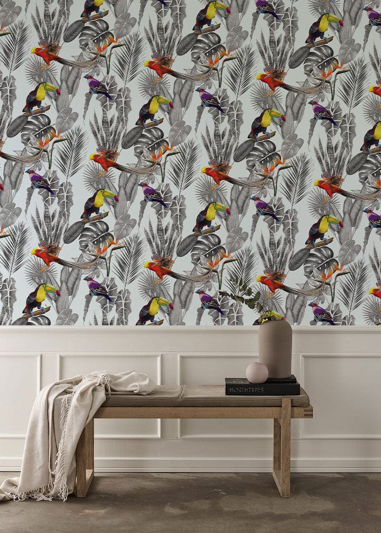 Tropical Paradise Jungle Birds mural wallpaper in grey, multicolour with wooden bench, beige wall panelling.