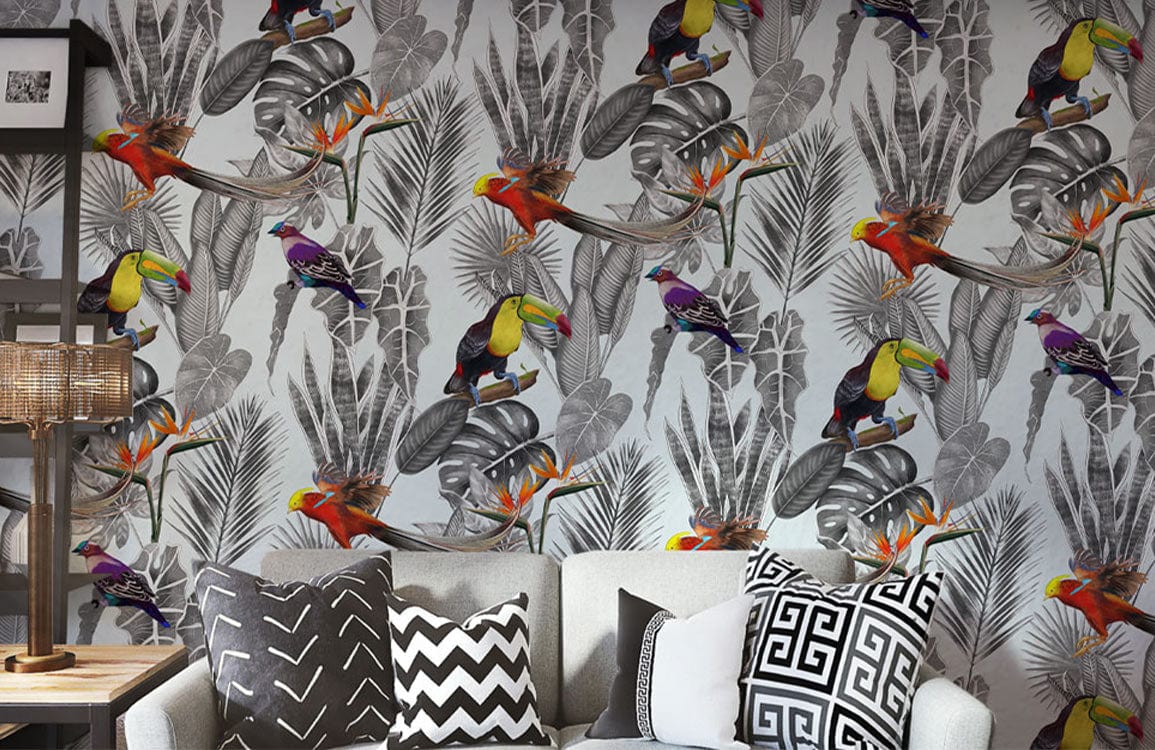 Tropical Paradise Jungle Birds mural wallpaper with grey sofa, patterned cushions, stylish living room decor.