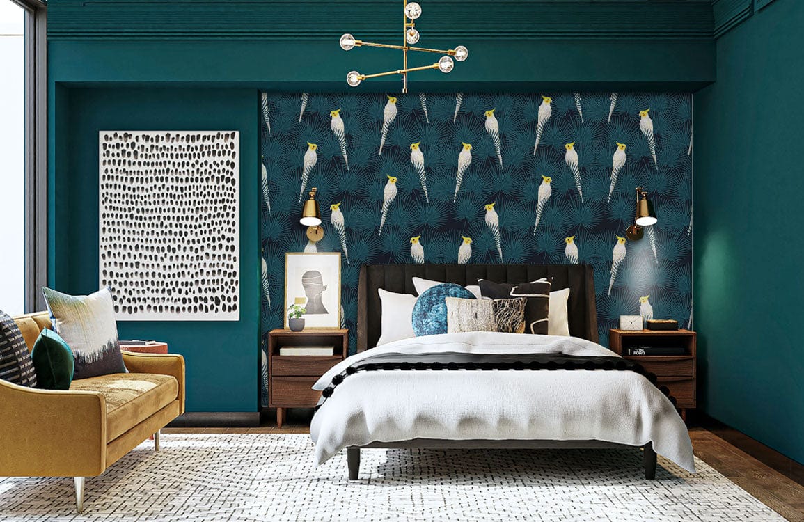 Teal tropical cockatoo wallpaper, contemporary bedroom, mustard sofa, wooden flooring, white bed linen, artwork.