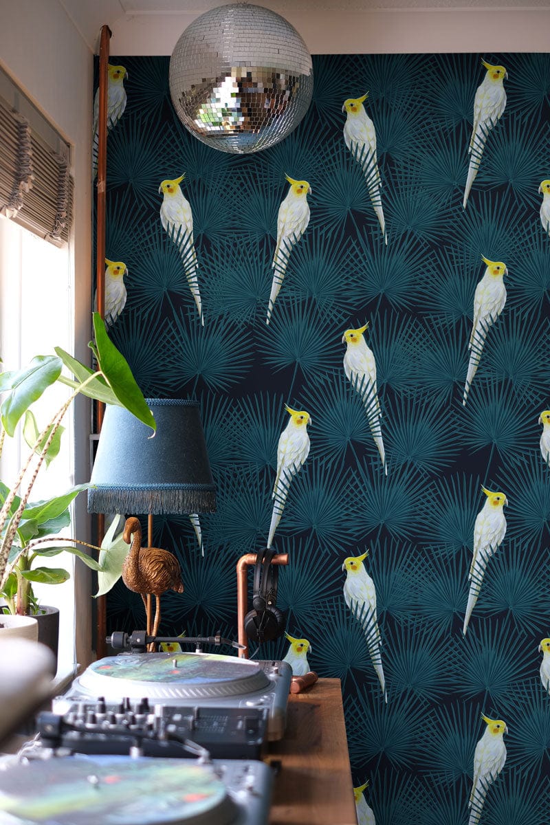 Tropical cockatoo wallpaper in teal, showcasing contemporary interior with disco ball and turntable setup.