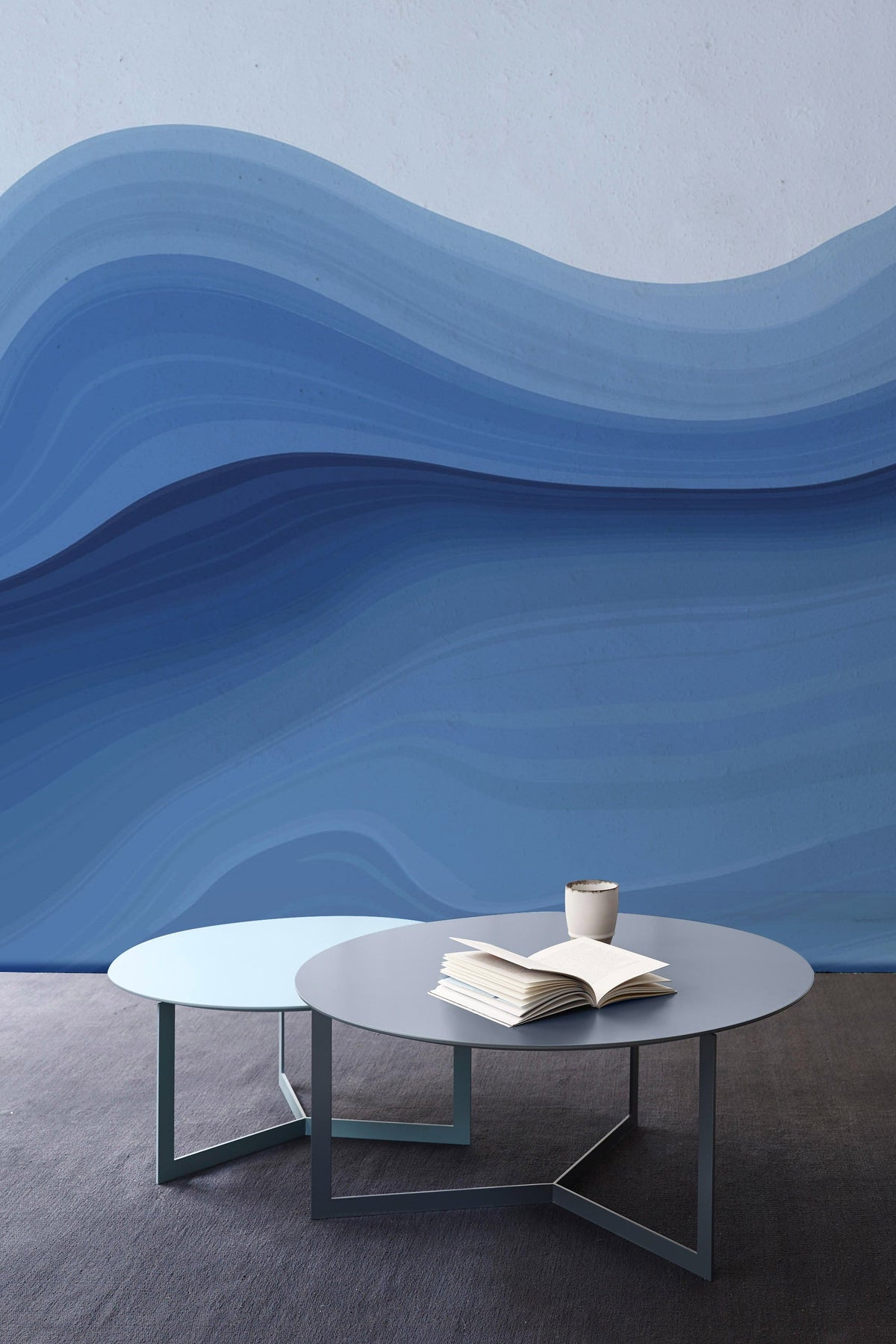 Elegant Blue Wave Gradient Mural Wallpaper in modern room with two grey tables and carpet flooring.
