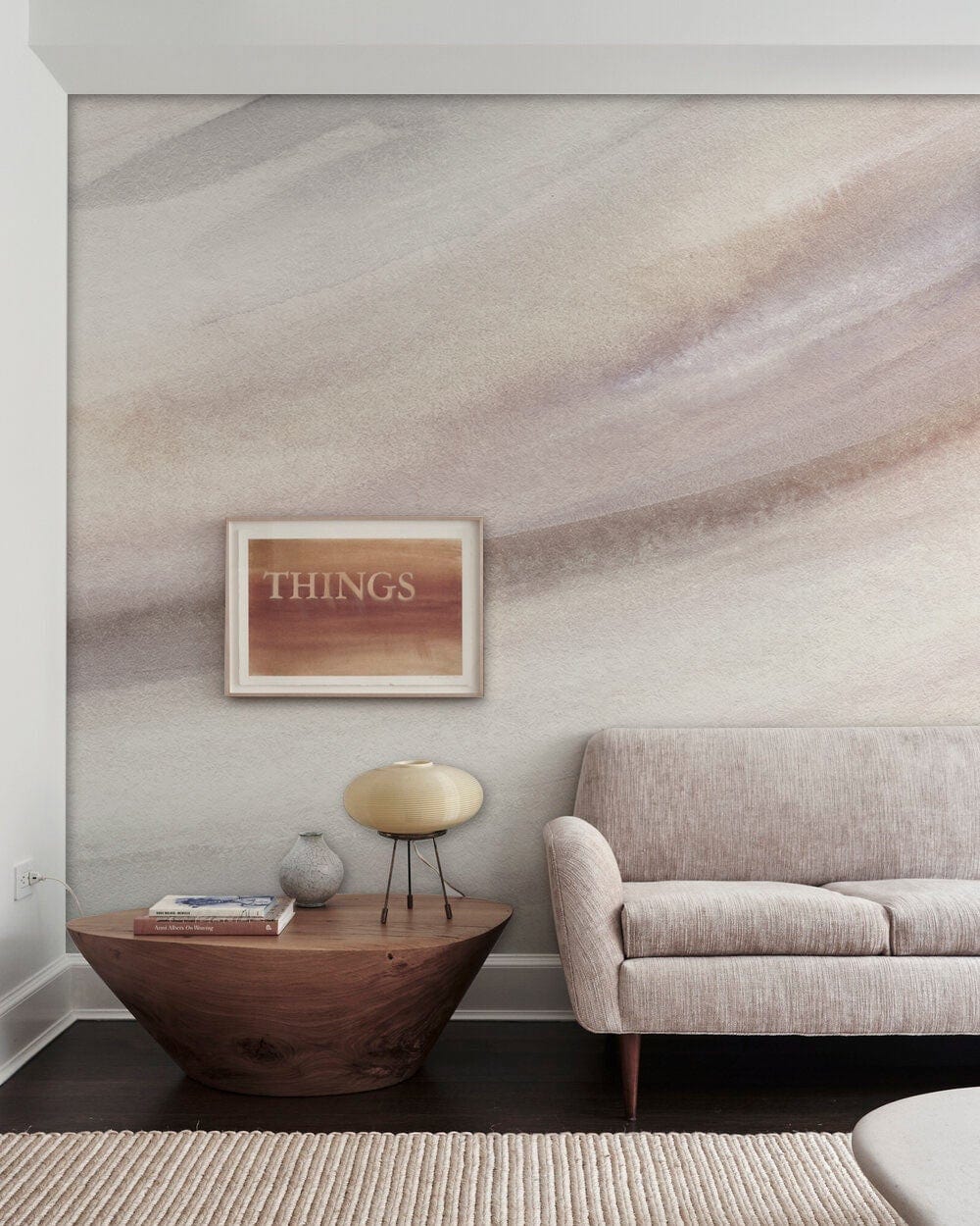 Elegant beige watercolour mural wallpaper in modern living room with beige sofa, wood table, framed artwork.