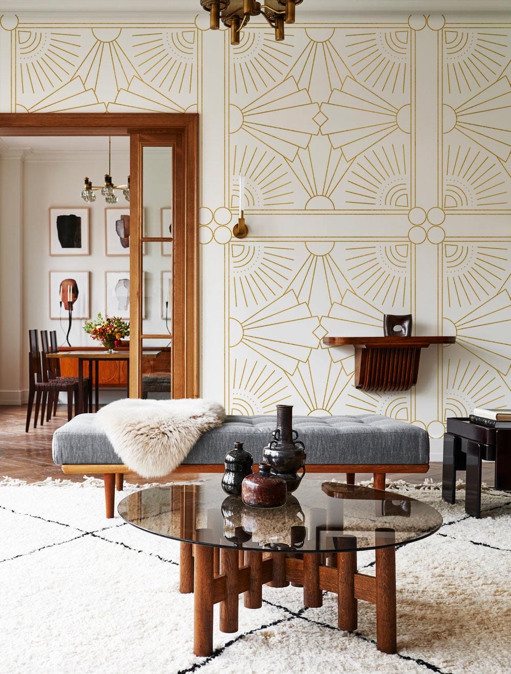 Golden Art Deco wallpaper in elegant living room with grey sofa and stylish geometric pattern.