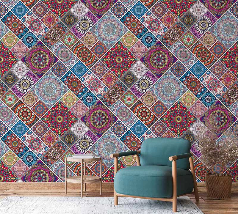 Vibrant multicolour geometric pattern mural wallpaper in bohemian style, teal armchair, wooden flooring.