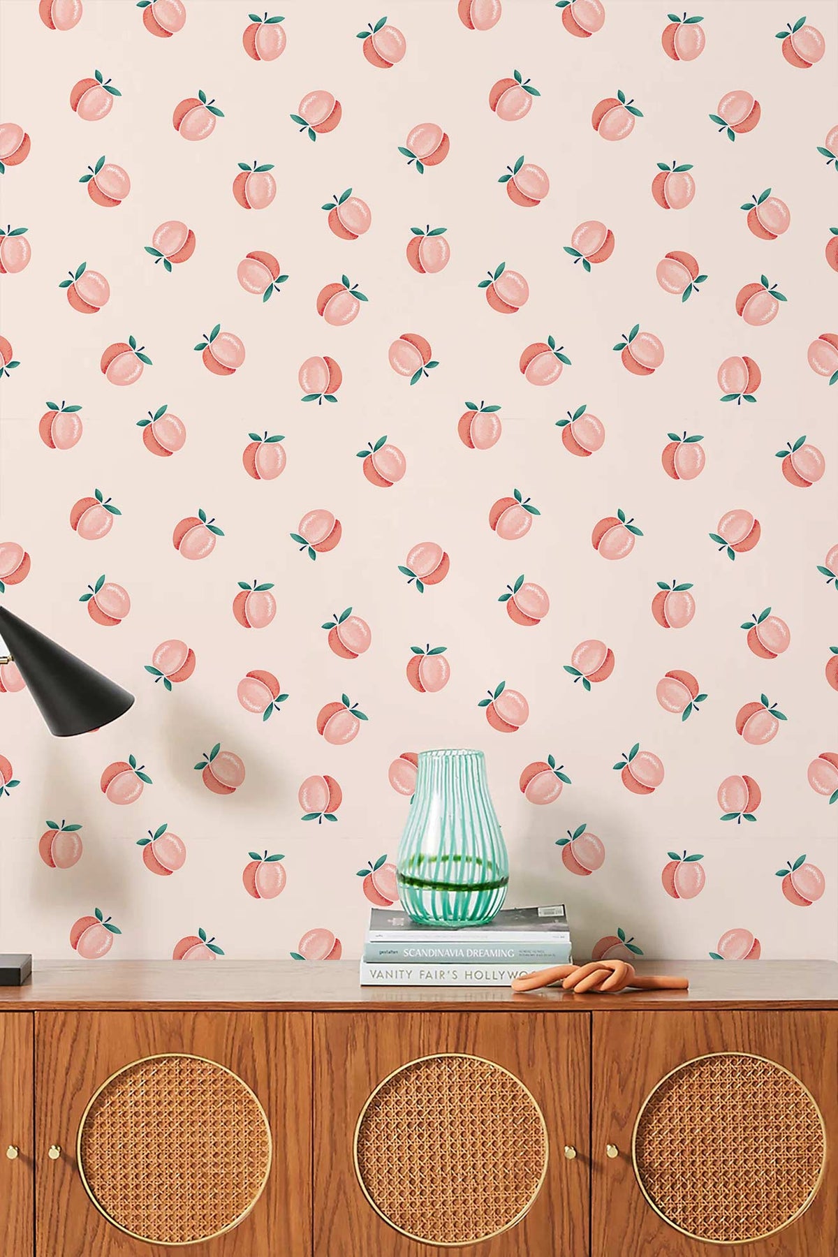 Charming peach pattern wallpaper in soft pastel with wooden sideboard and stylish black lamp.