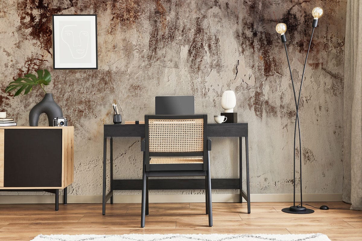 Rustic industrial wall mural with vintage texture, office desk, black chair, modern floor lamp, wooden flooring.