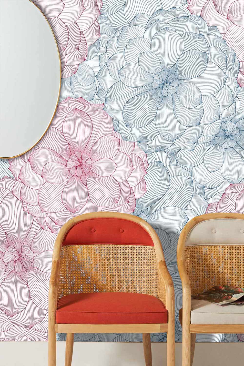 Elegant pastel floral wallpaper with pink and blue blooms, cane chairs, mirror, stylish living room.