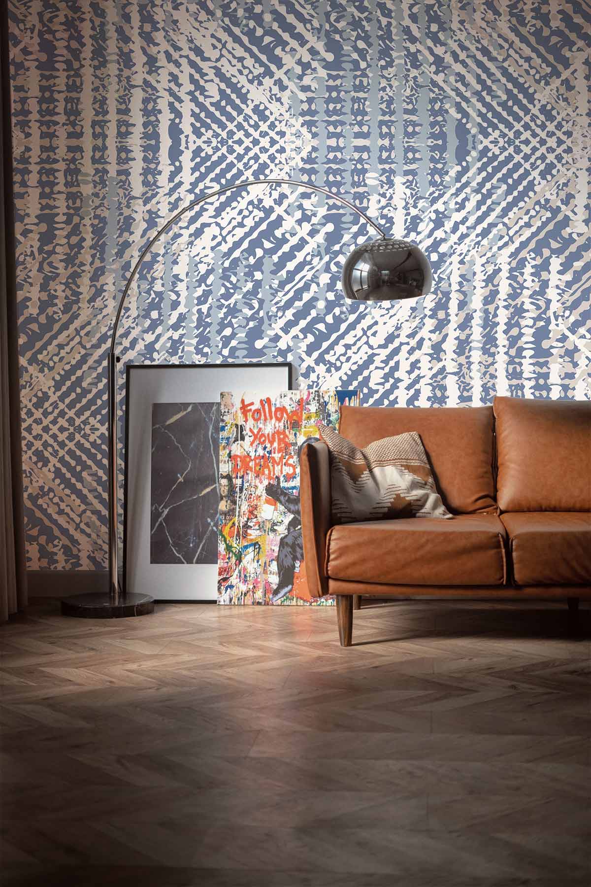 Elegant geometric wallpaper, modern brown sofa, parquet flooring, arc floor lamp, and artwork in interior.