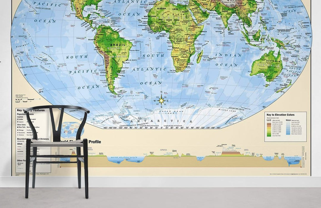 Chair on grey floor with Vintage World Map Mural Wallpaper, green and blue adventure theme.
