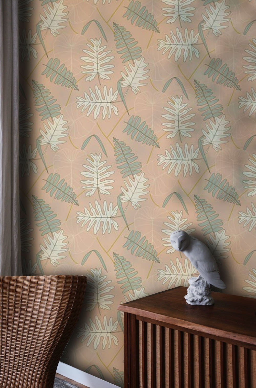 Vintage botanical leaf pattern wallpaper in soft peach and sage green with wooden furniture accent.