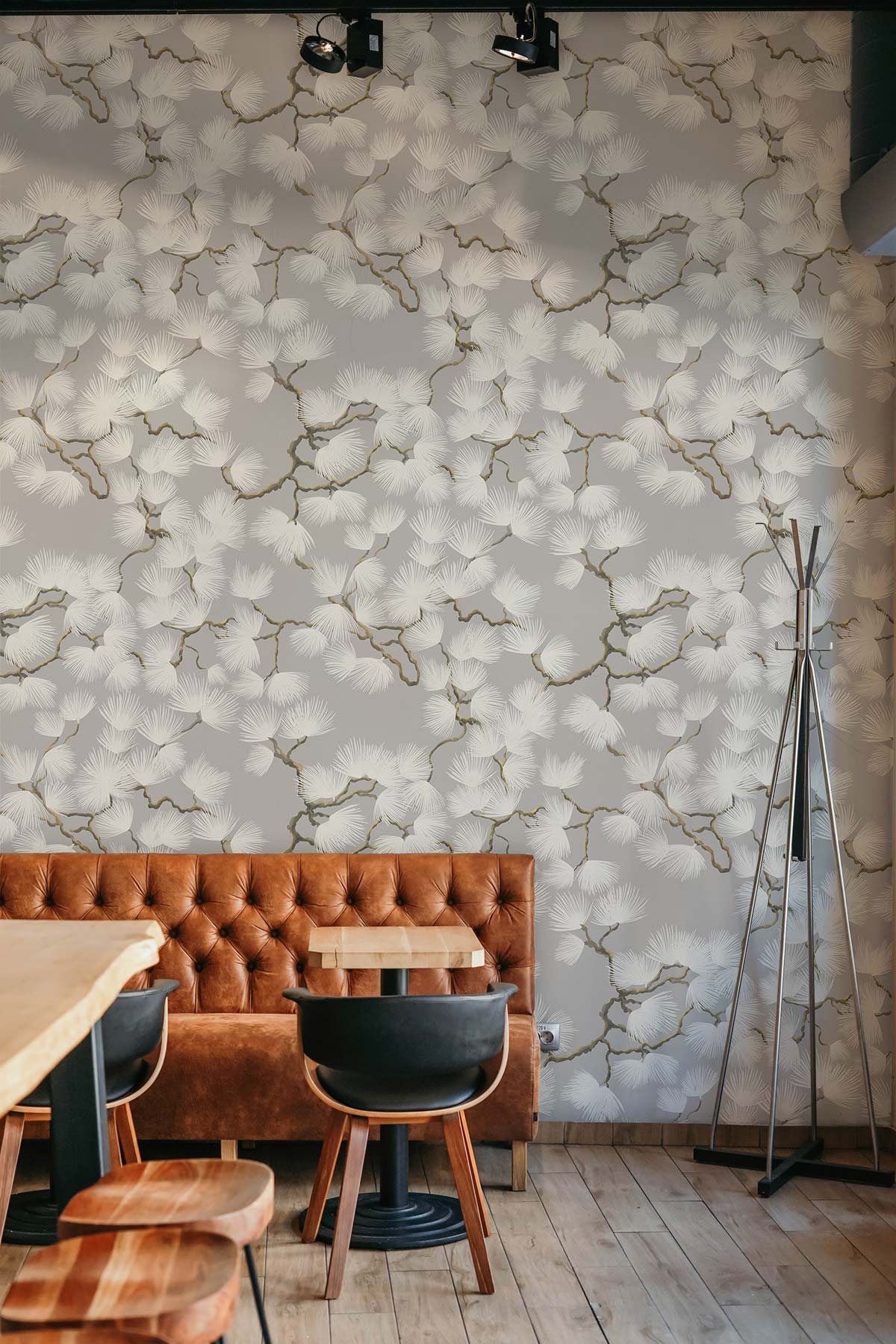 Elegant grey floral wallpaper; contemporary sofa, wooden flooring, chic dining chairs in modern dining room.