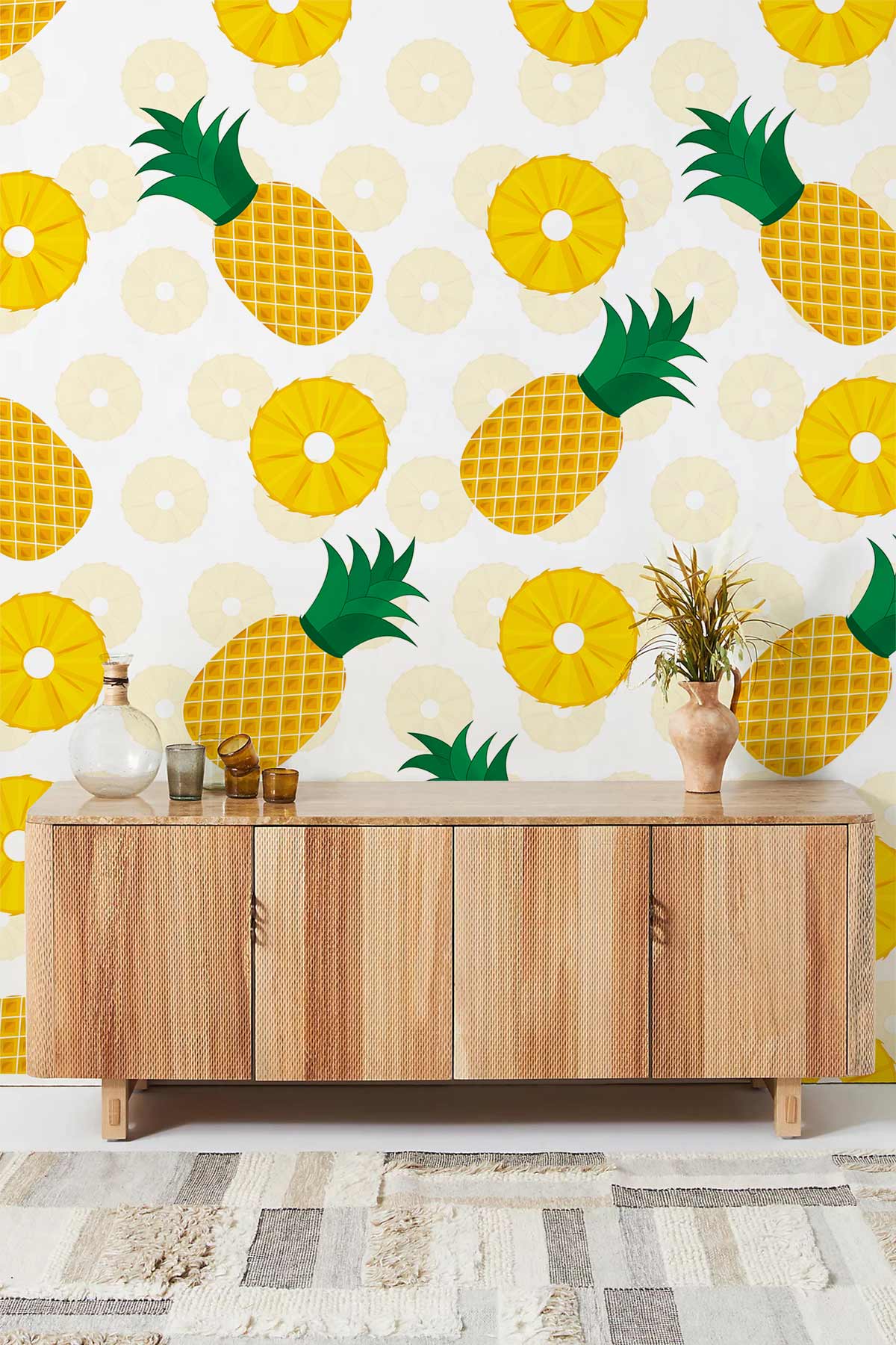 Tropical Pineapple Wallpaper in vibrant yellow, green, white. Wooden cabinet and patterned rug featured.