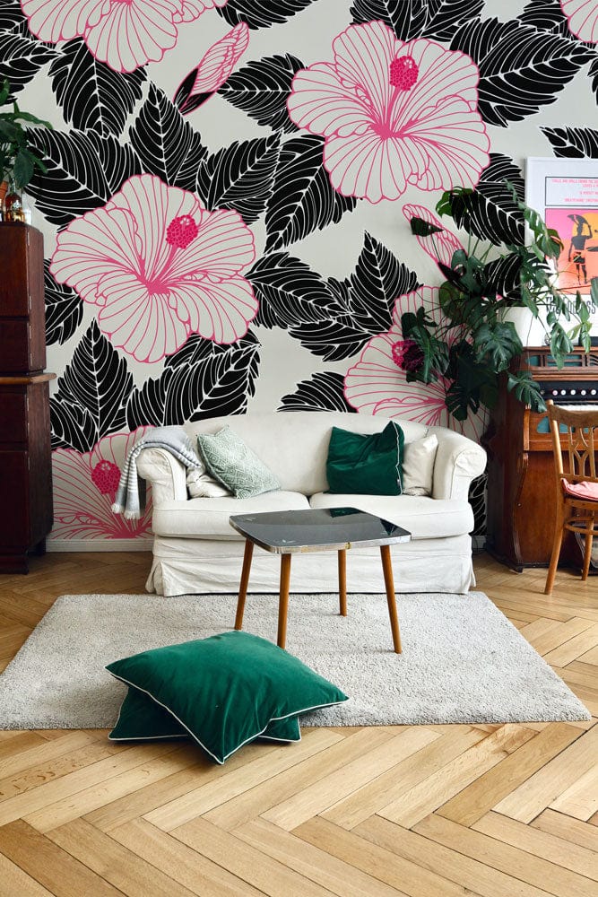 Elegant pink hibiscus wallpaper with black leaves, white sofa, green cushions, parquet flooring, living room.