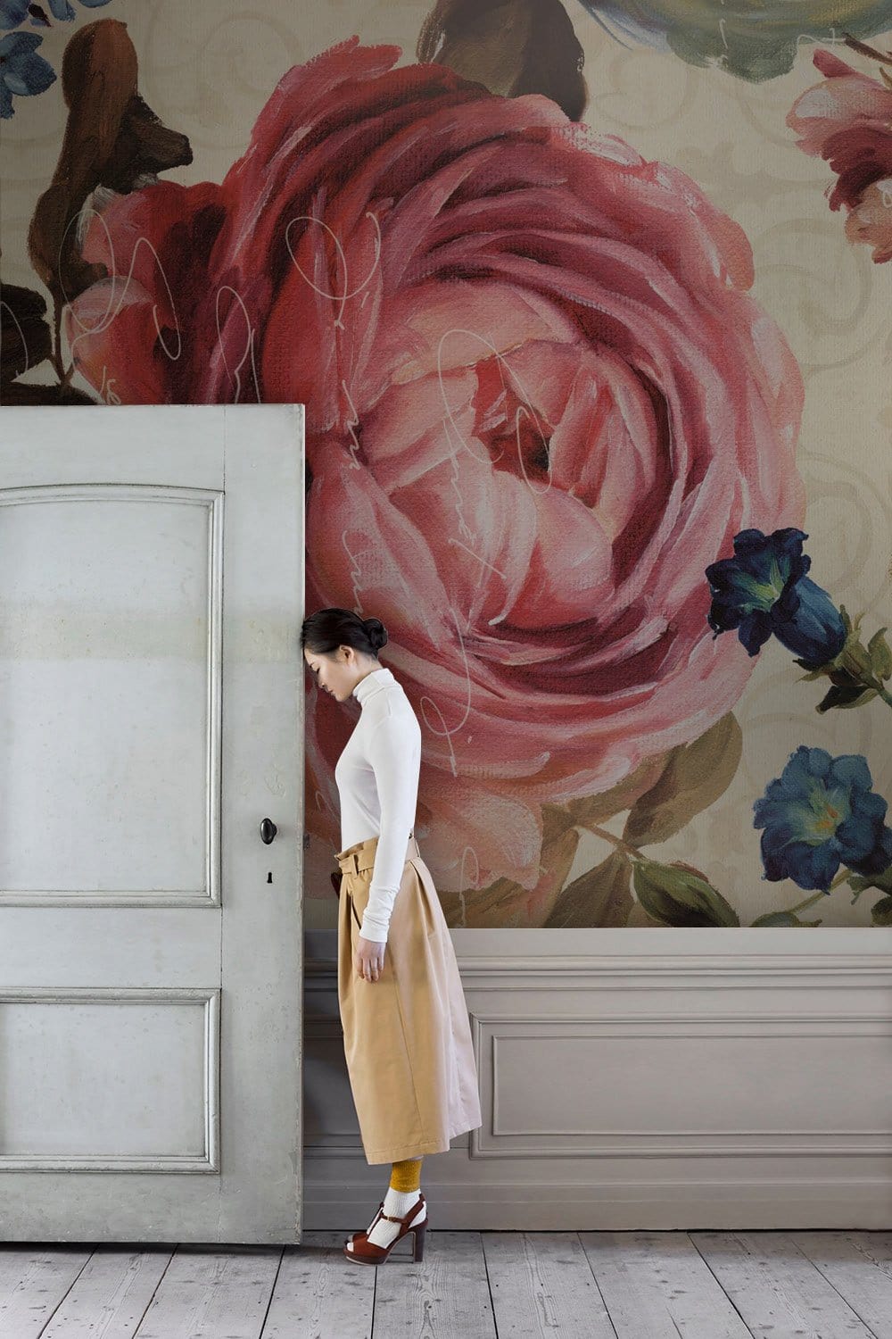 Vintage floral mural wallpaper featuring pink roses on cream canvas with wooden flooring in hallway.