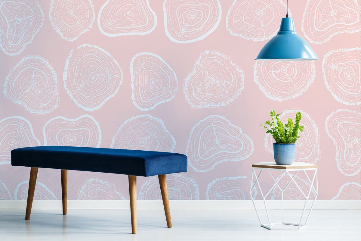 Pastel pink tree rings wallpaper, blue pendant lamp, modern bench, light wood floor in living room.
