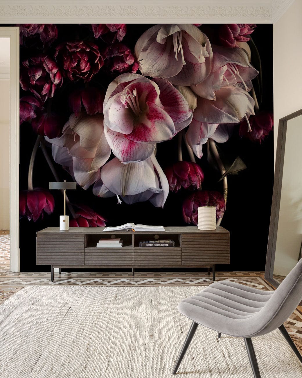 Luxurious dark floral wallpaper in living room with grey chair, rug, and modern sideboard.