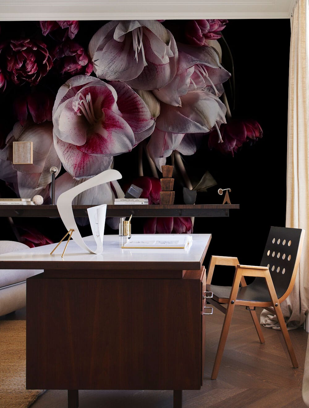 Luxurious dark floral wallpaper in office; wooden desk, modern chair, dark floor, artistic decor elements.