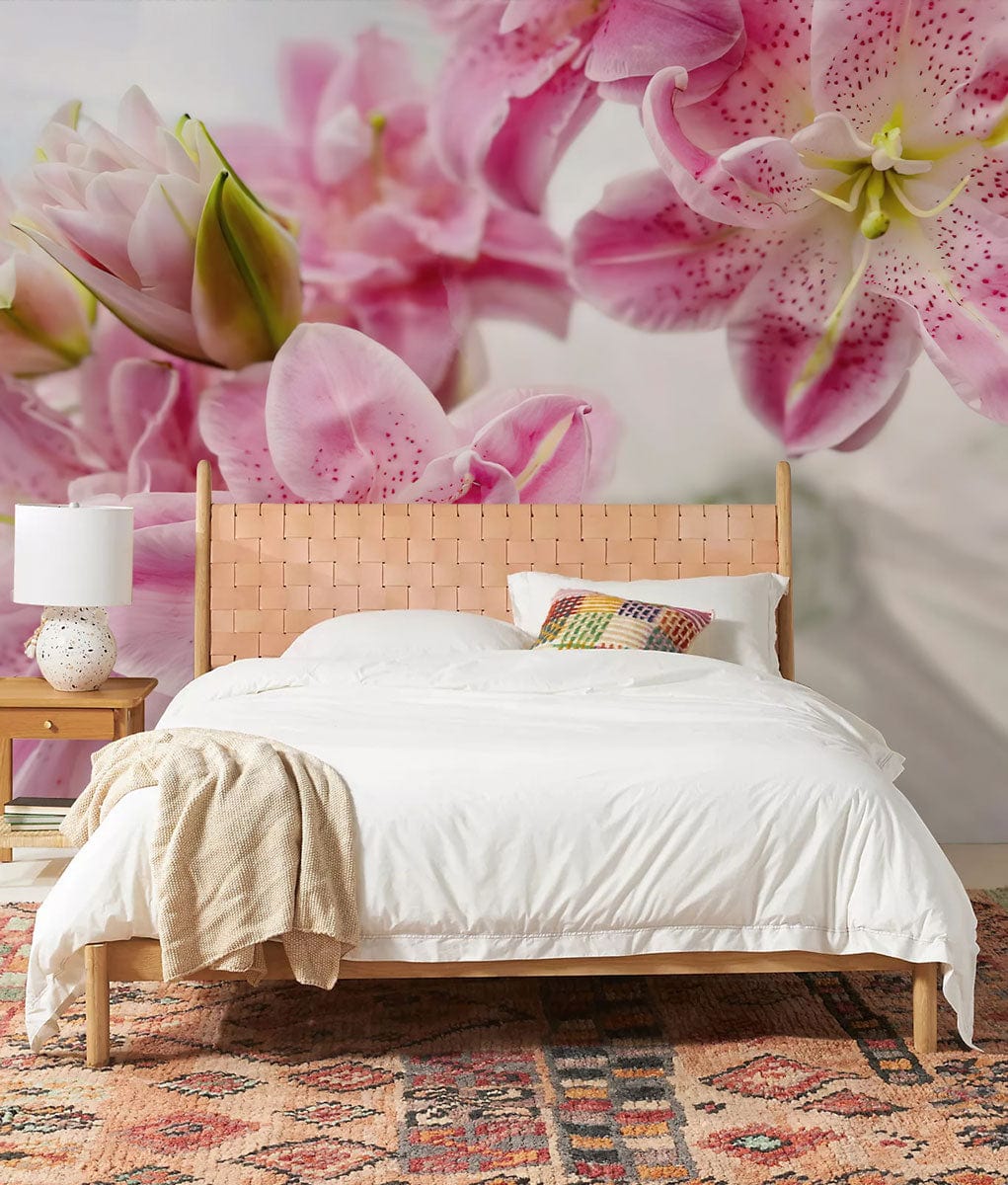Elegant floral mural wallpaper behind woven bed, white bedding, wooden nightstand, rug, and pastel pink lilies.