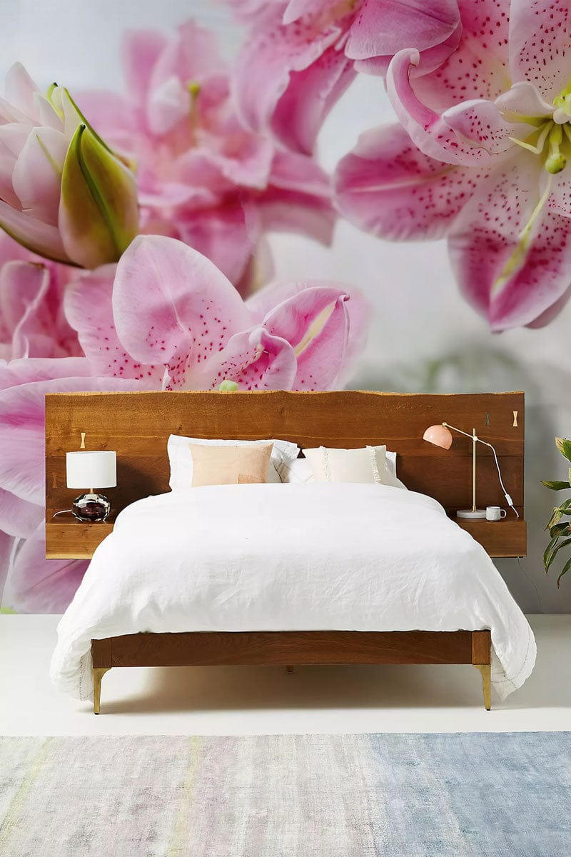 Elegant pink lily wallpaper in modern bedroom with wooden bed, white bedding, and soft pastel rug.