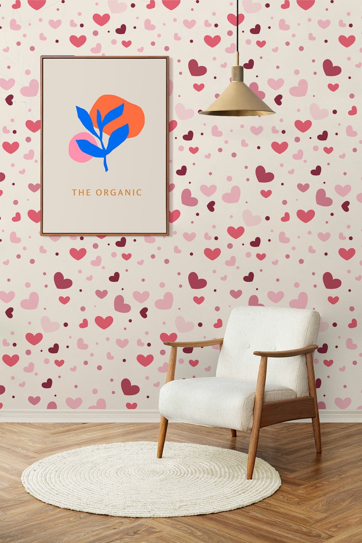 Charming pink hearts wallpaper with white armchair, wood flooring, pendant light in cosy room.