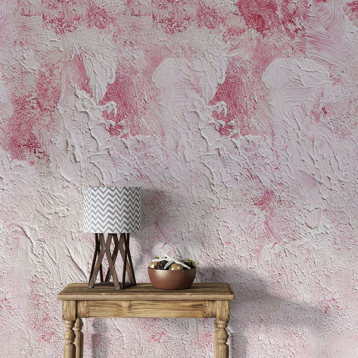 Blush pink textured abstract wall mural, wooden side table, and zigzag lamp in modern interior.