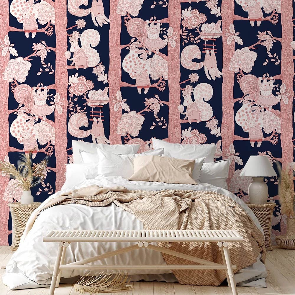 Pink and navy children's mural wallpaper with woodland creatures, white bed, woven bench, bedroom.