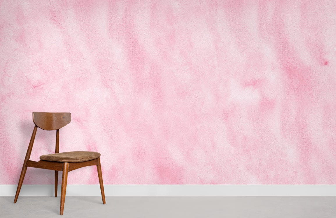 Soft pink watercolour mural wallpaper in minimalist room; wooden chair; elegant pastel interior design.