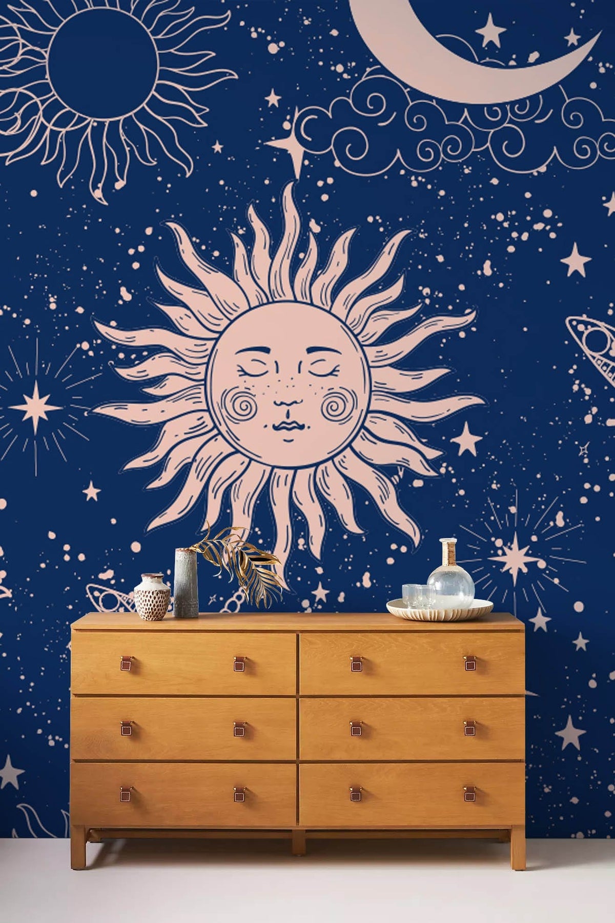 Midnight blue celestial wallpaper with sun, moon, dragonfly pattern; wooden chest of drawers.