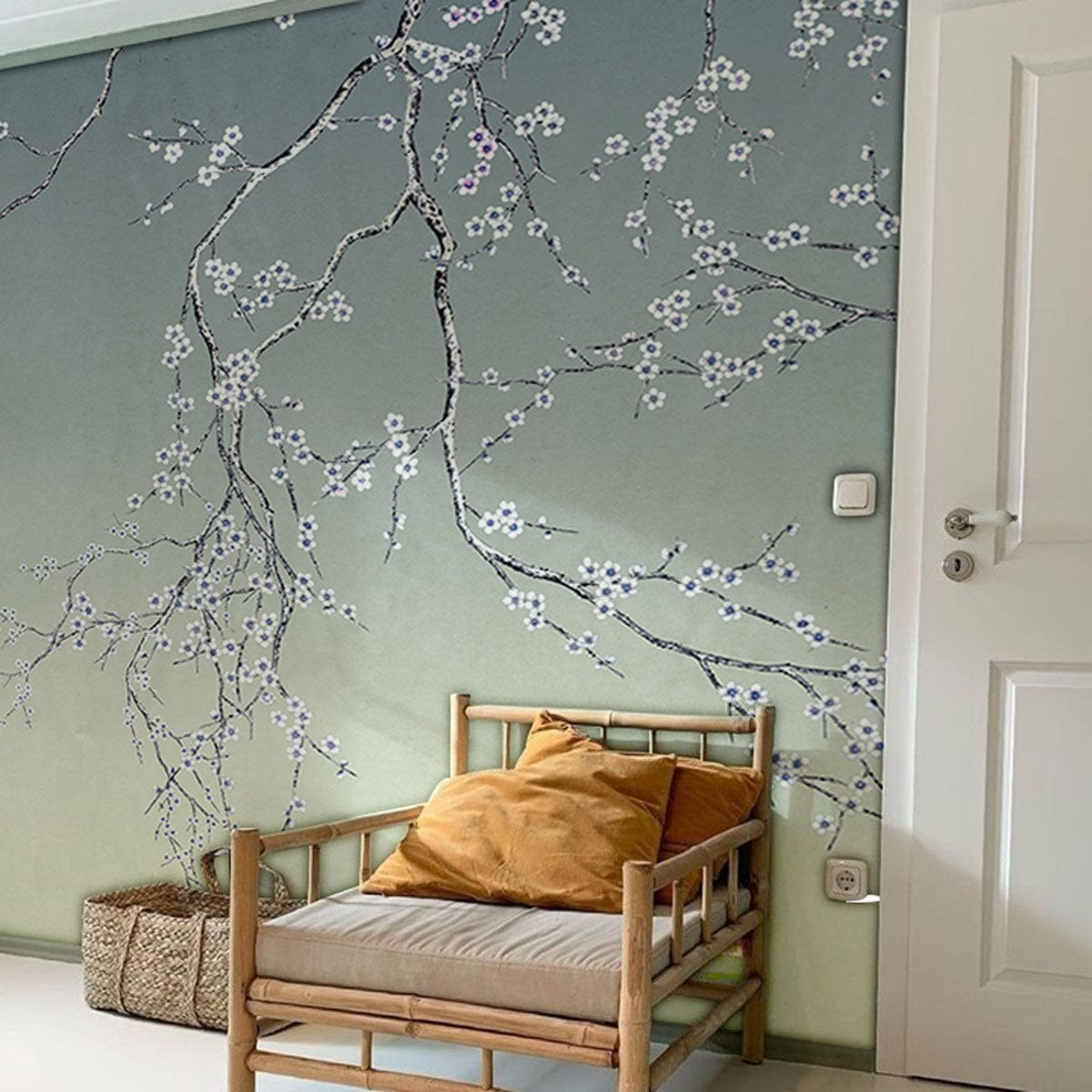 Elegant Blossom Branches Wallpaper in living room with bamboo chair, white door, and green-grey gradient mural.