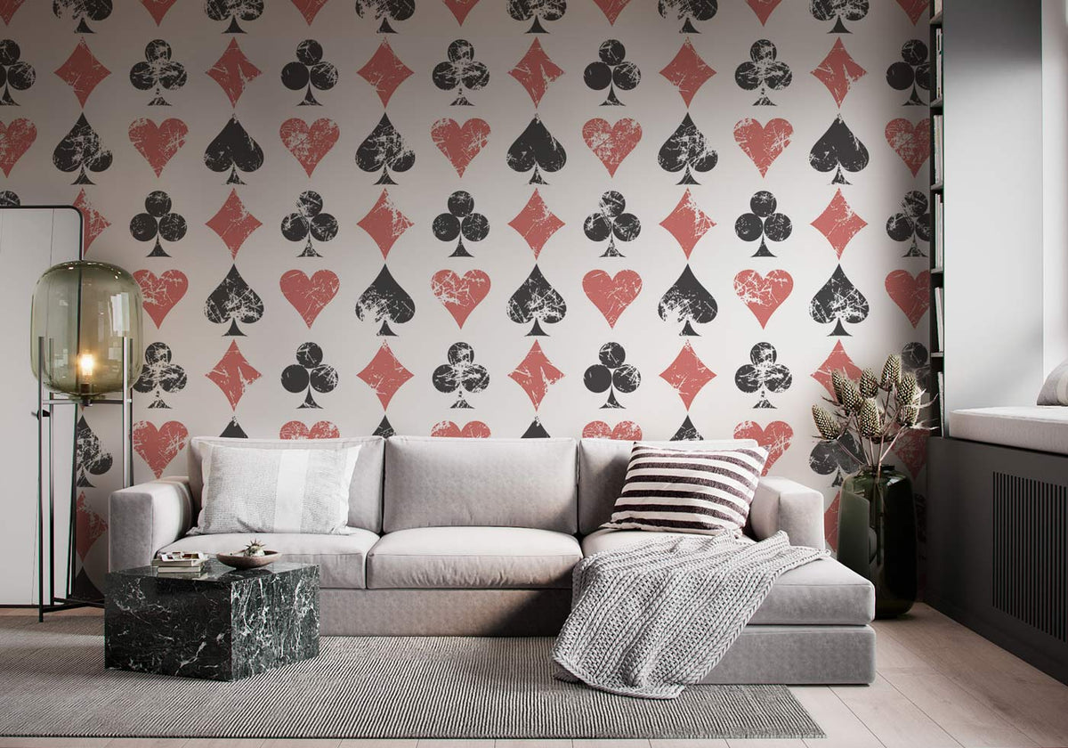 Vintage playing card themed wallpaper; black and red pattern, grey sofa, wooden flooring, modern lounge.