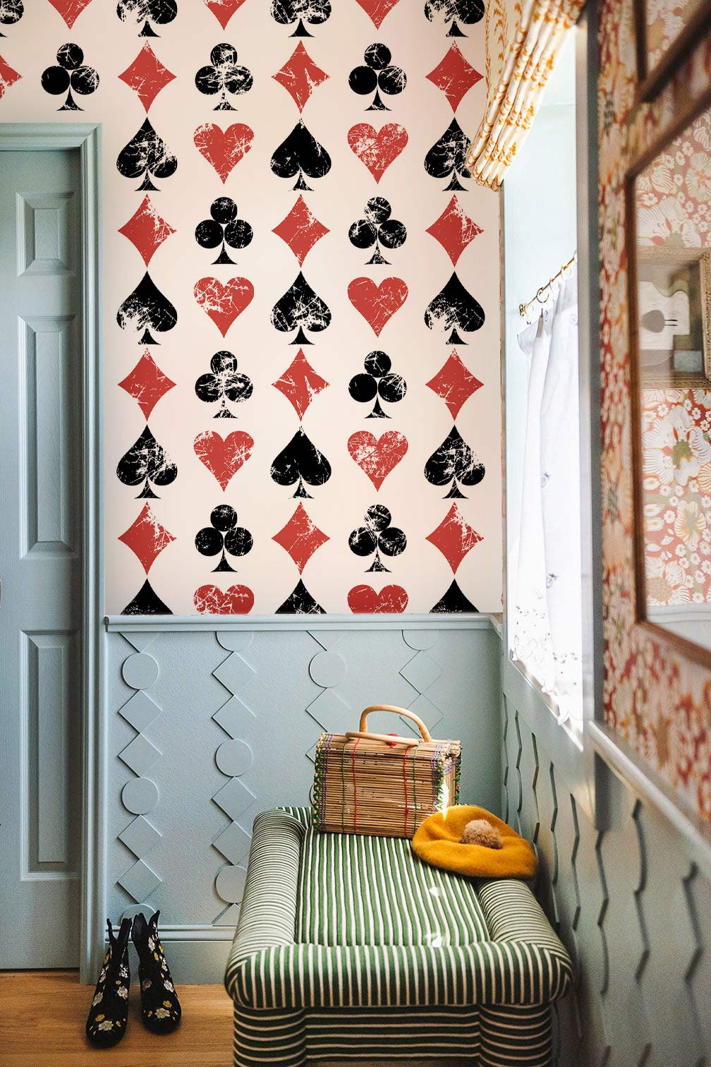 Vintage playing card wallpaper in narrow hallway; striped bench, pastel wall panelling, wooden flooring.