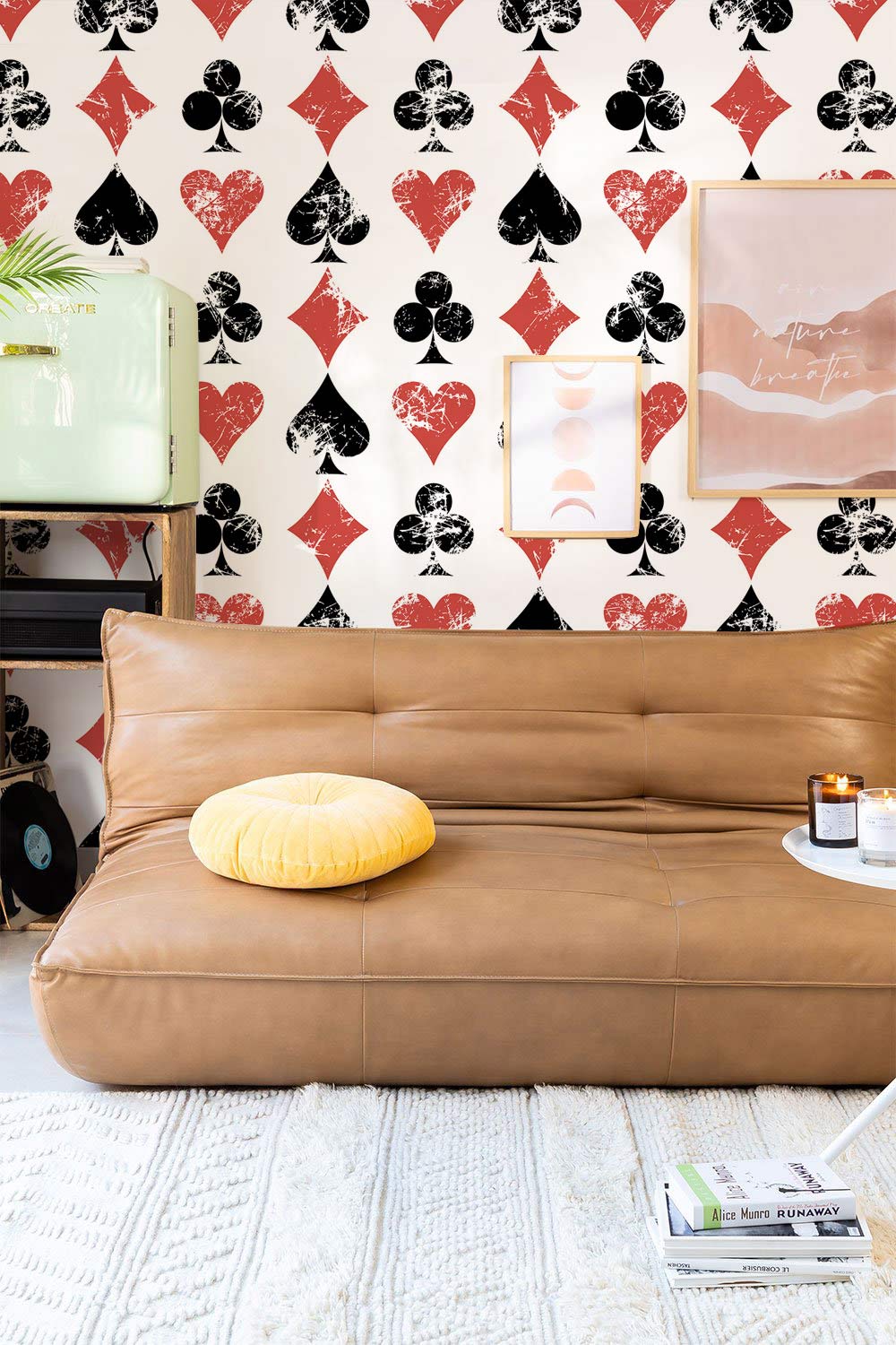 Vintage playing card wallpaper, brown leather sofa, cream rug, modern art, retro room interior design.