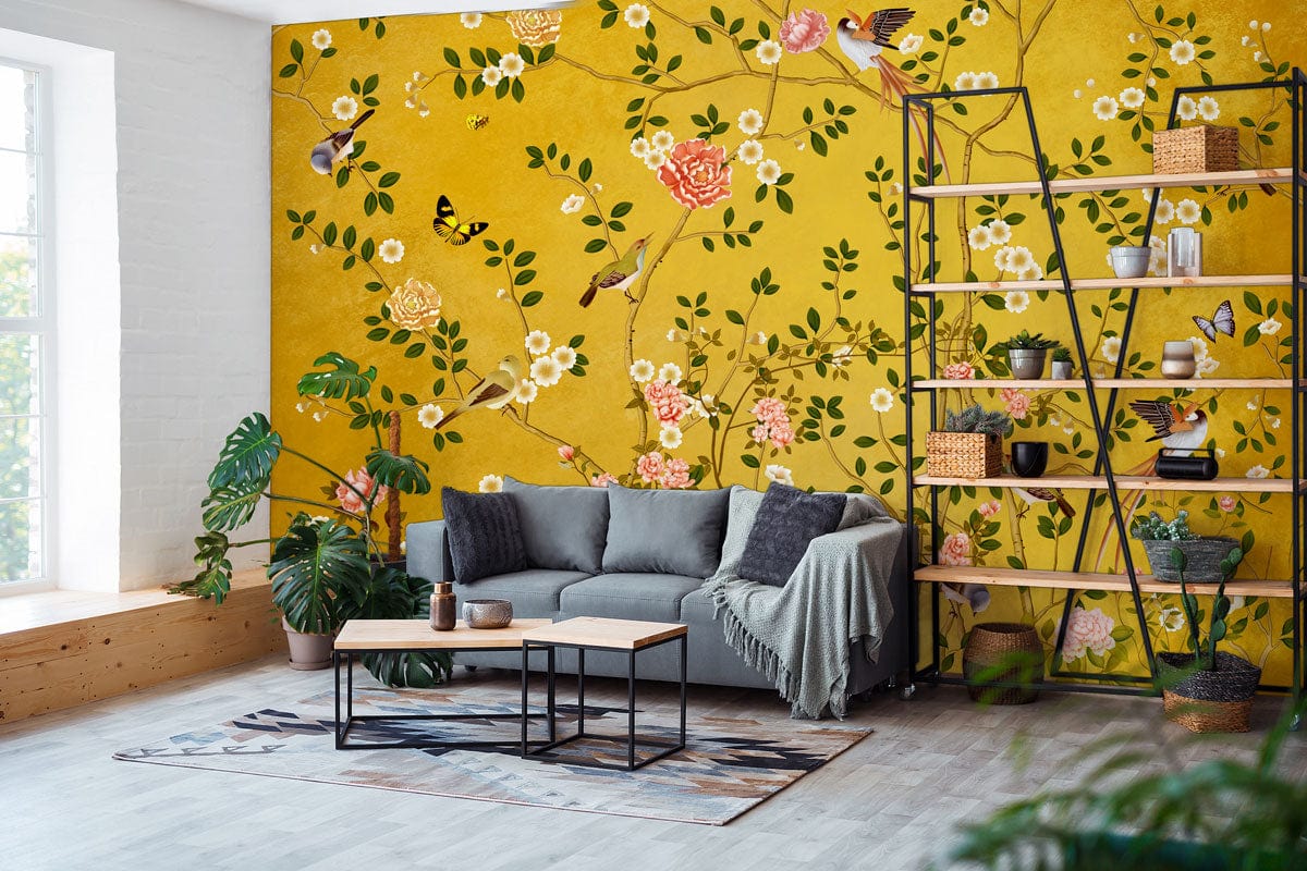 Golden Floral Garden Mural Wallpaper featuring birds with grey sofa, industrial shelving, and wooden flooring.