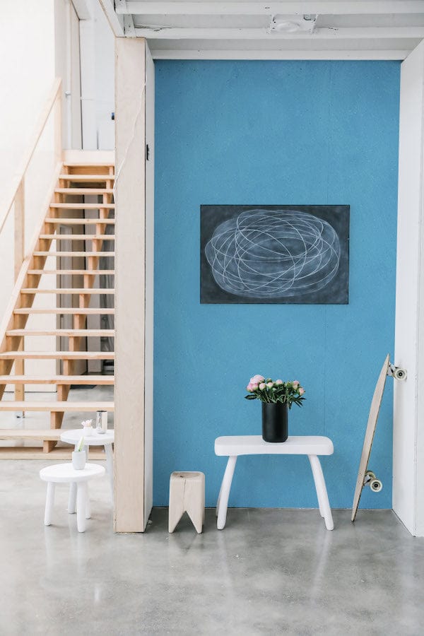 Elegant sky blue textured mural wallpaper with modern decor, light wooden stairs, and concrete flooring.