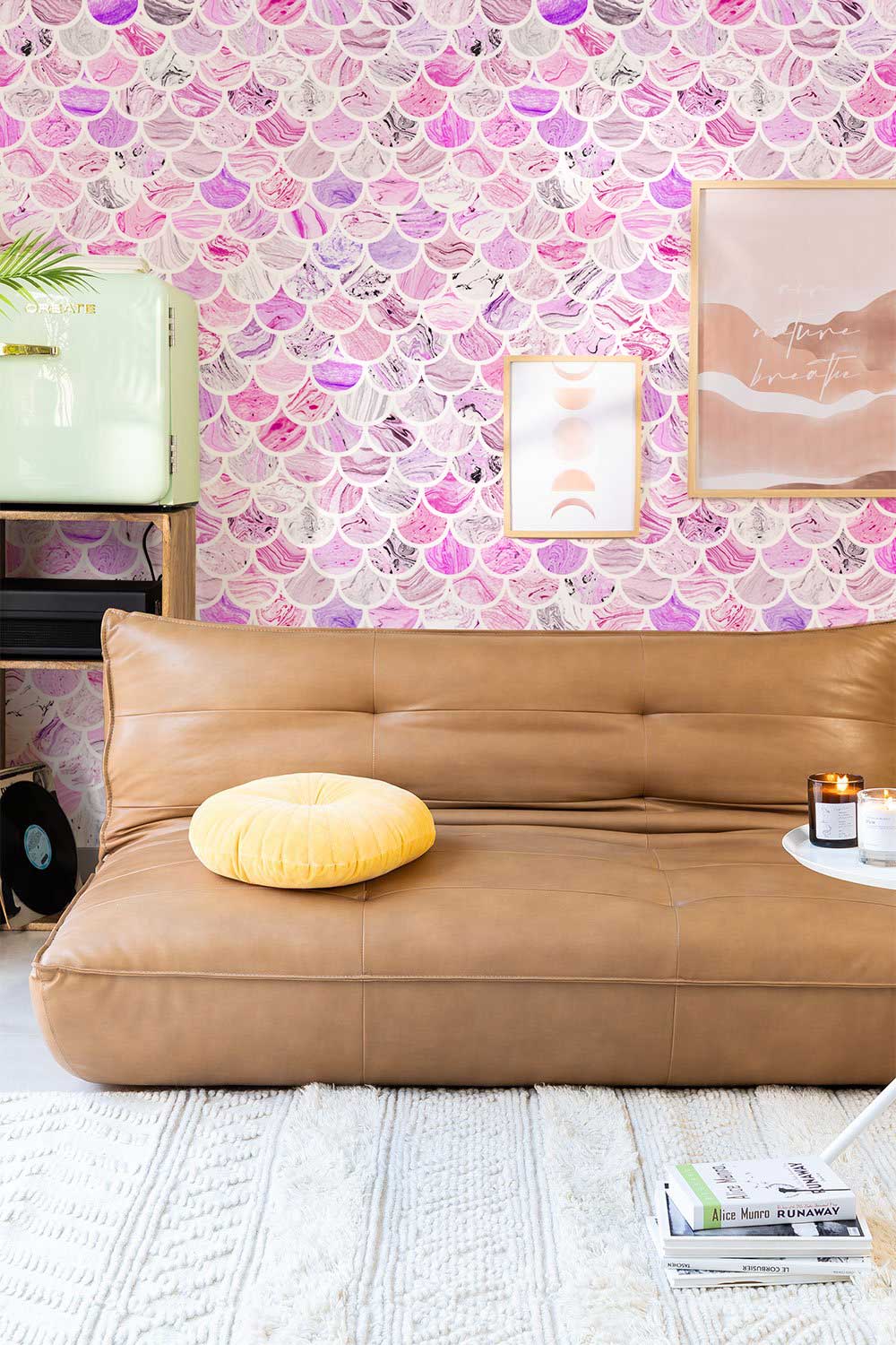 Elegant pink and lavender scallop wallpaper, brown leather sofa, wall art, modern living room.