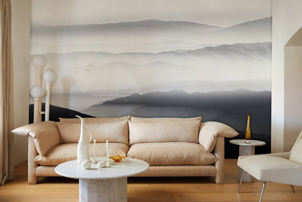 Misty Mountains Grey Mural Wallpaper in elegant lounge with beige sofa, marble table, and soft lighting.